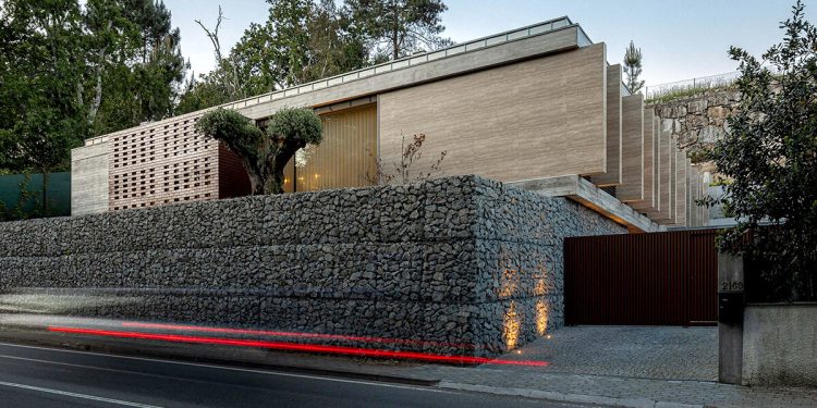 La casa CL de Artequitectos combina paredes de gabión con una fachada de travertino en Portugal
