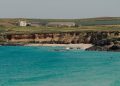 En la playa de tres millas en Cornwall, una luna de babys bajo