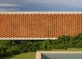 La fachada de ladrillo puntúa la casa de concreto de Fernanda Padula en Brasil