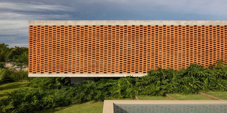 La fachada de ladrillo puntúa la casa de concreto de Fernanda Padula en Brasil