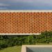 La fachada de ladrillo puntúa la casa de concreto de Fernanda Padula en Brasil
