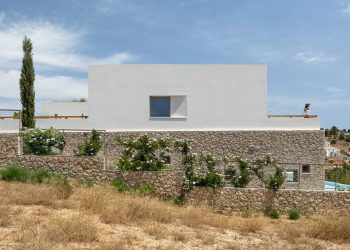 Pieris Architects incrusta la residencia de piedra en capas en la ladera griega