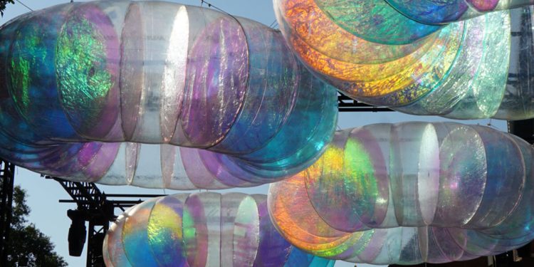 La instalación de óculo flotante brilla con una luz cromática cambiante