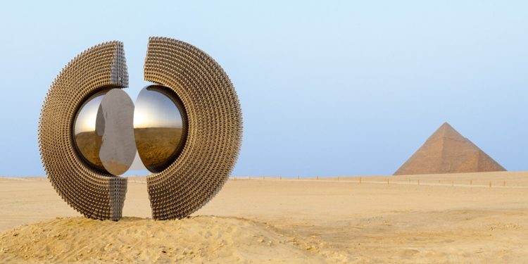 La escultura de anillo reflectante de Mert Ege Köse enmarca las pirámides de Giza.