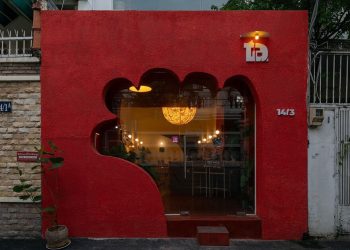La fachada roja de un café talla una entrada con forma de mano en Vietnam