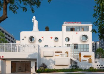 El diseño dika da forma a un divertido jardín de infantes interestelar coronado por una escultura de astronauta.