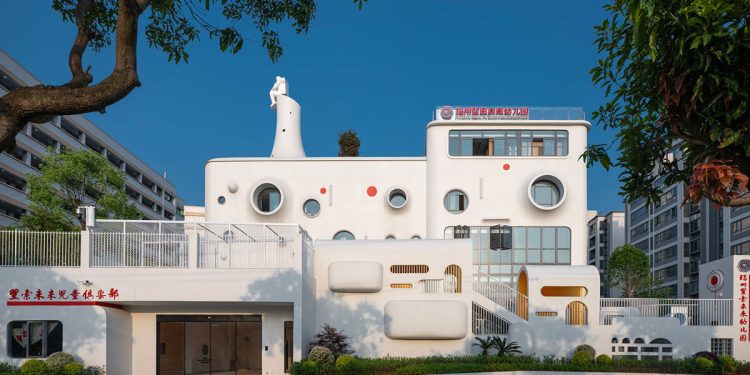El diseño dika da forma a un divertido jardín de infantes interestelar coronado por una escultura de astronauta.